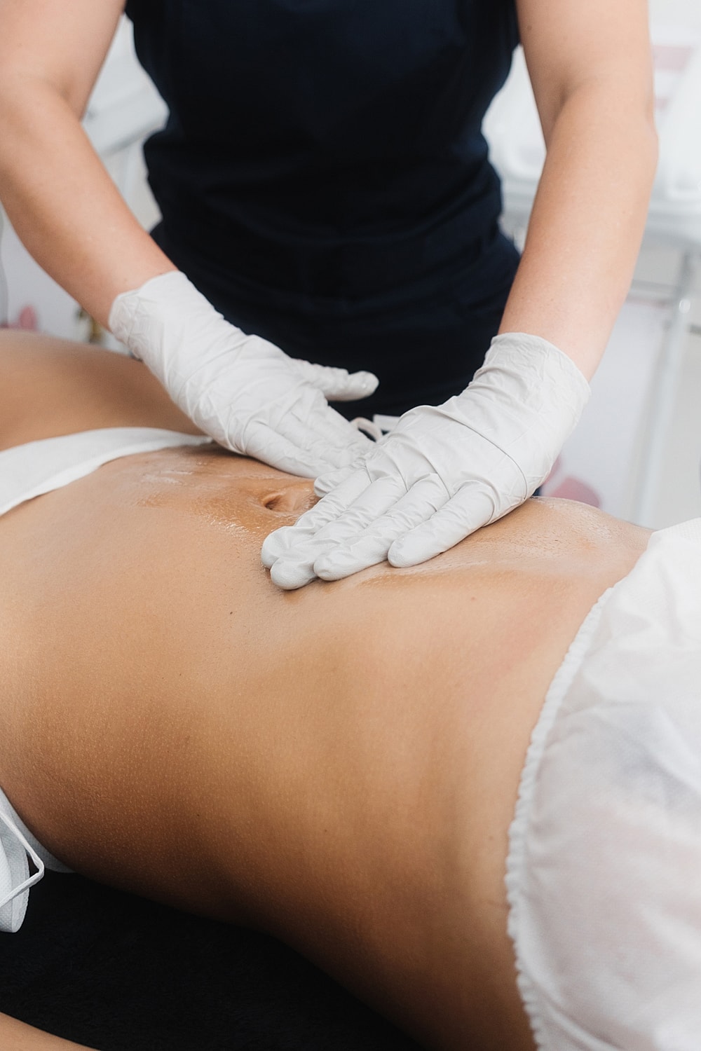 Massage therapy on a client's abdomen.