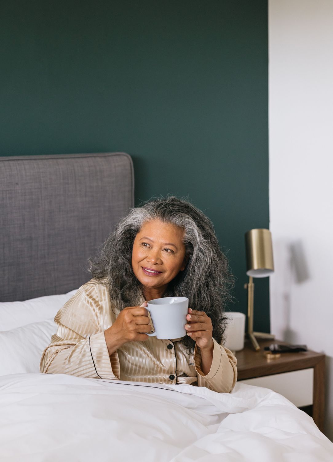 Woman enjoying morning coffee in bed.