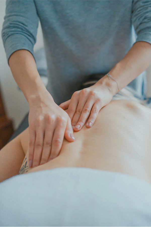 Massage therapist working on client's back.