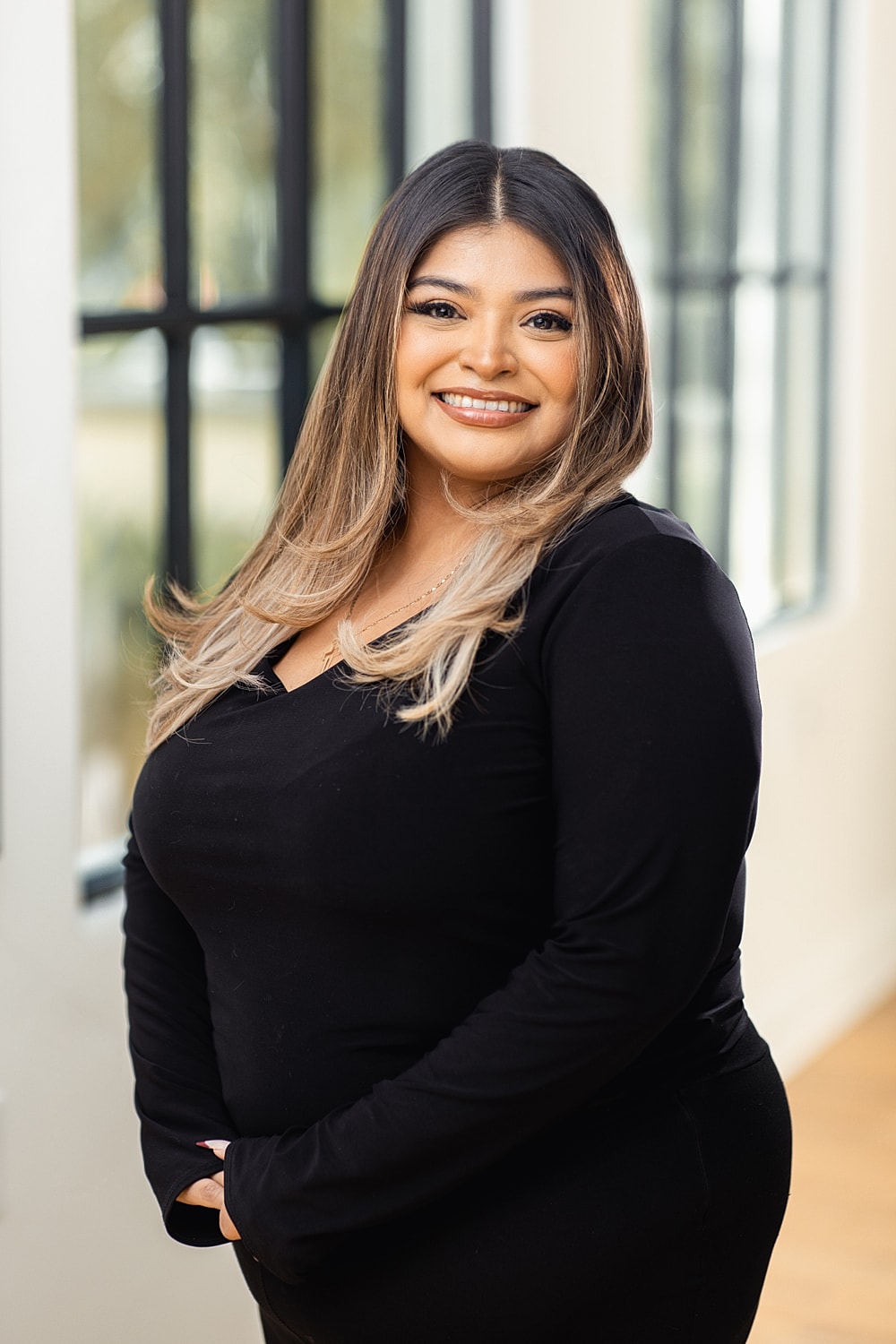 Smiling woman in a black outfit indoors.