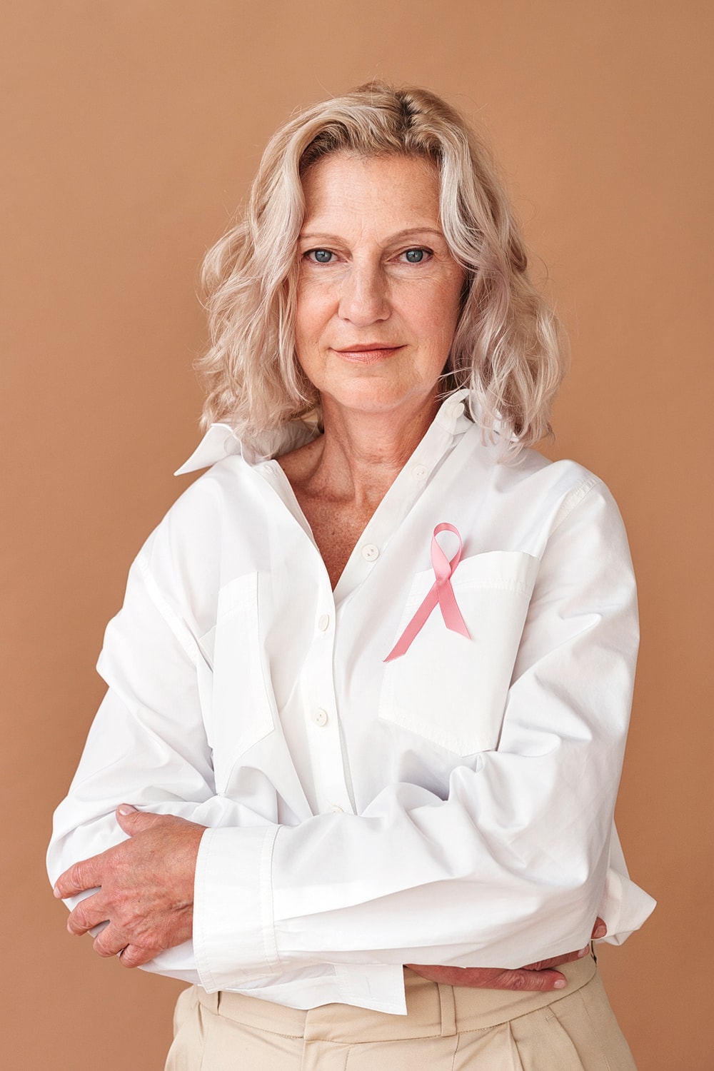 Woman wearing white shirt with pink ribbon.